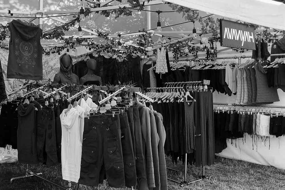 Avanyah clothing shop market stand at a psychedelic trance festival, showcasing vibrant art wear and festival fashion.